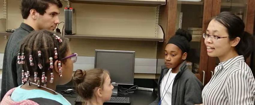 Students working with kids in a lab