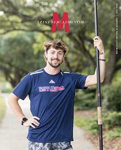 MCOB studentin track and field shirt holding pole.