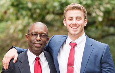 Professor and male student with arm around each